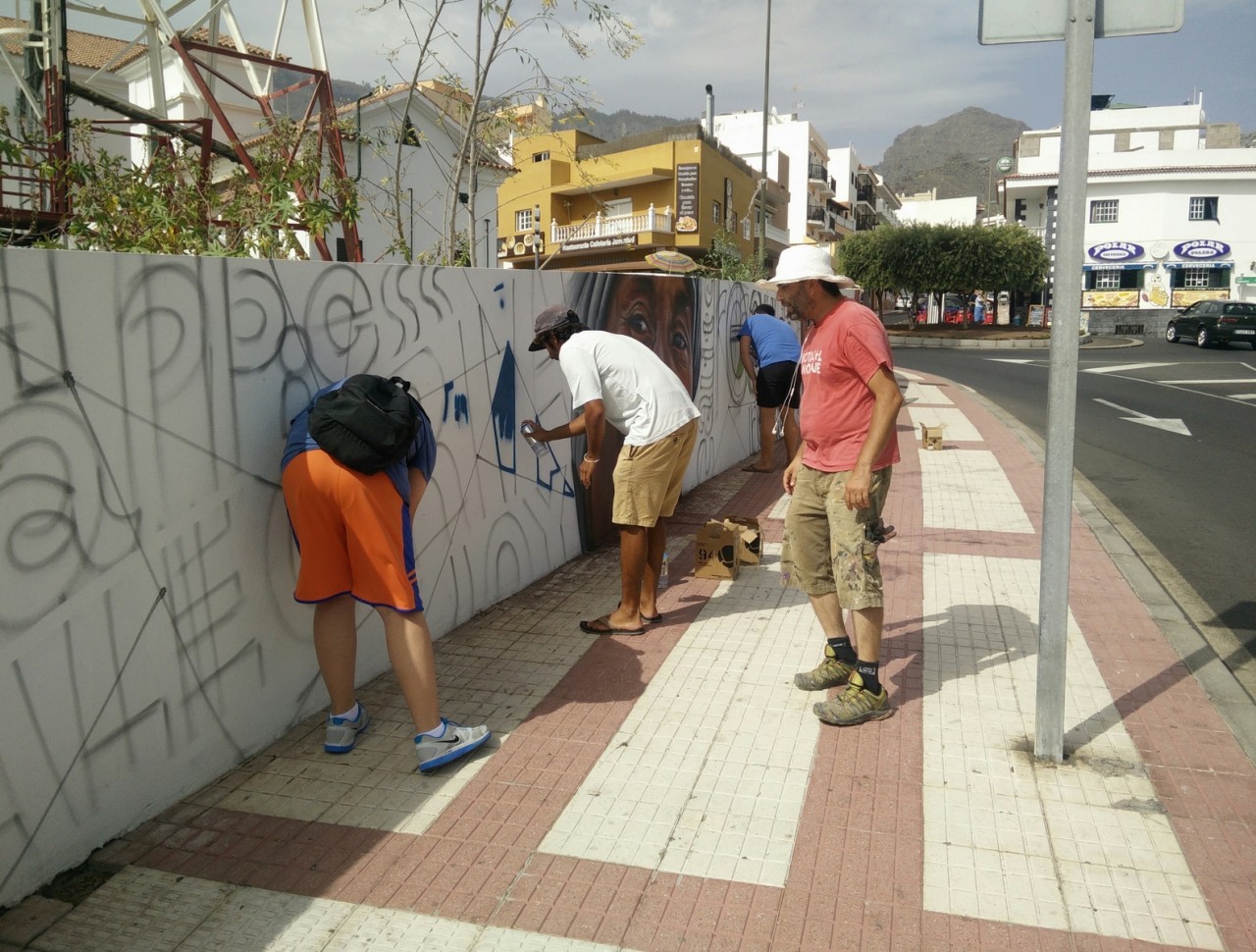Jóvenes colaborando en la creación del mural