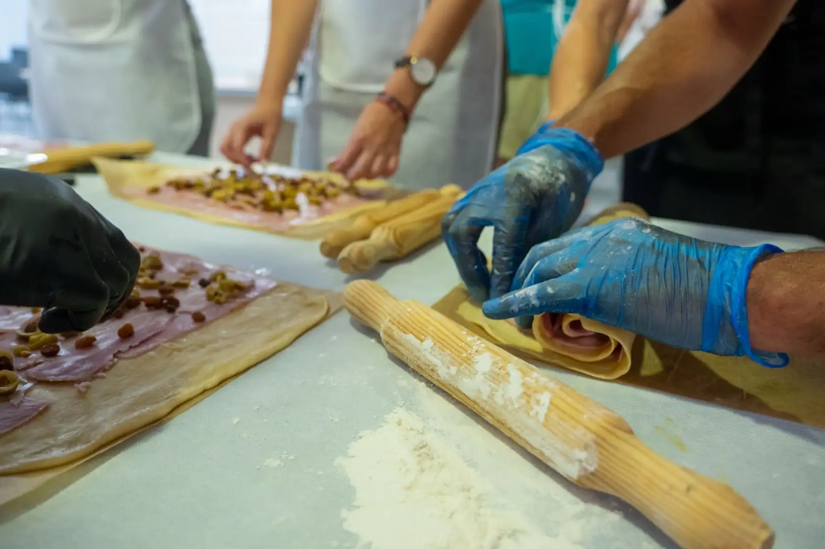 Formaci&oacute;n en cocina en Adeje con preparaci&oacute;n de masa rellena por personas con guantes